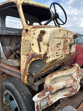 Rust-covered vintage car interior with a focus on the dashboard and steering wheel.