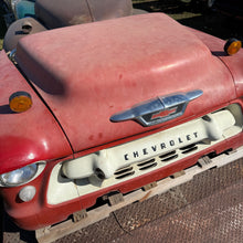 Close-up of a red Chevrolet vehicle with visible wear and tear.